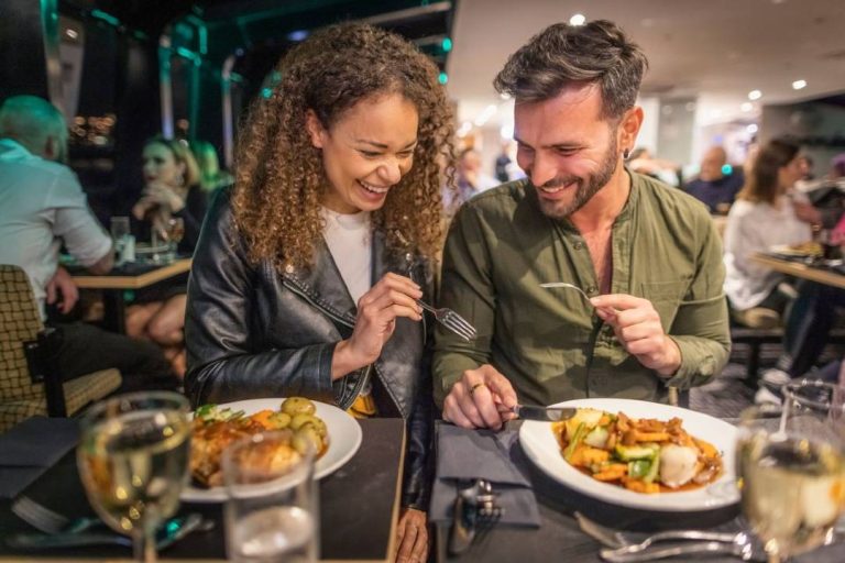 A photo of two people enjoying food on a Dinner Cruise.