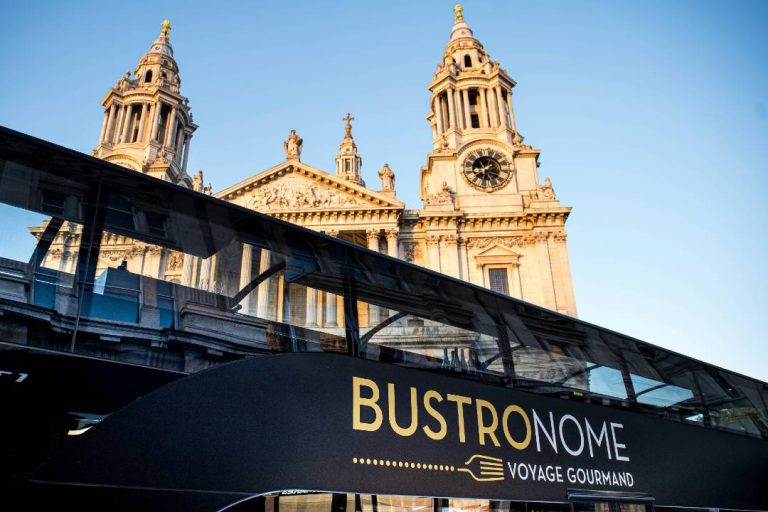 A photo of a Bustronome bus in front of St Paul's cathedral.